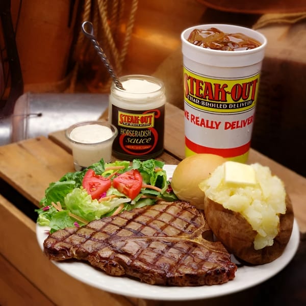 Steak-Out T-bone steak dinner with baked potato, salad, horseradish sauce, and a drink.